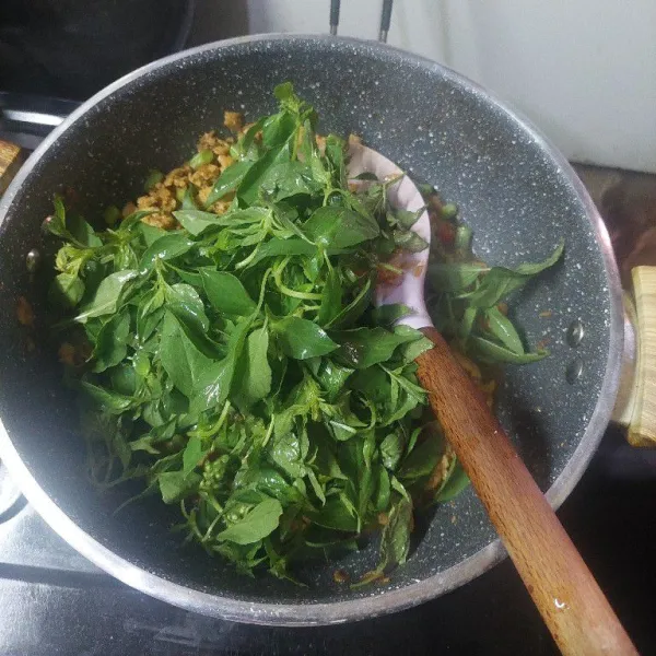 Masukkan kemangi, aduk kemangi sampai layu.