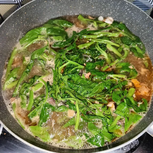 Setelah mendidih, masukkan kangkung dan aduk rata. Masak sampai matang dan koreksi rasanya, lalu matikan kompor.