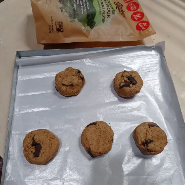 Siapkan loyang yang sudah di beri baking paper, kemudian ambil secukupnya adonan bentuk bulat lalu agak pipihkan, tata pada loyang.