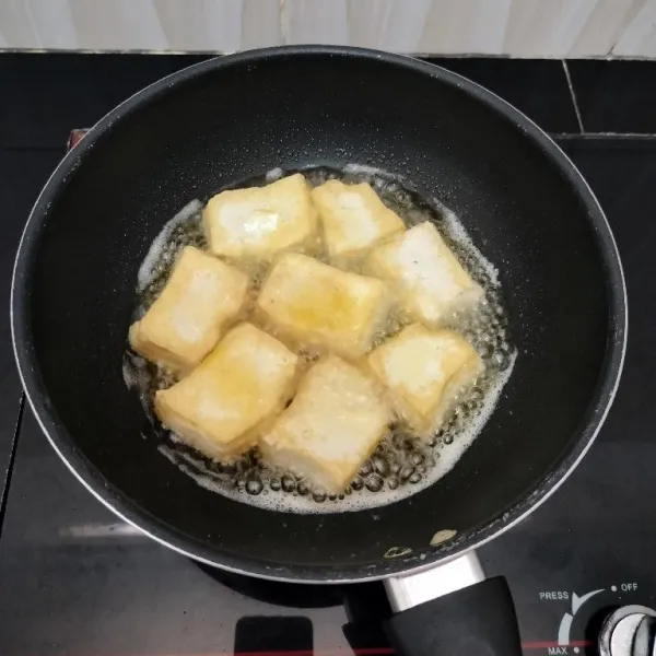 Potong-potong tahu, lalu goreng hingga berkulit, kemudian tiriskan.