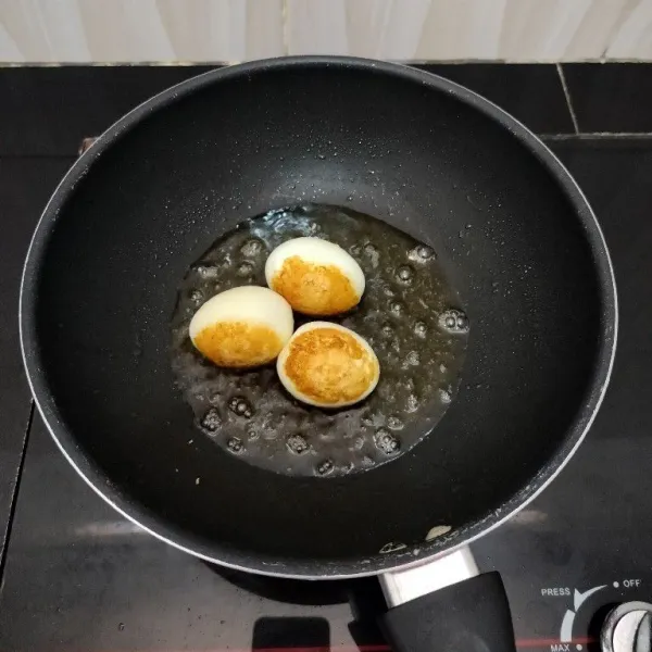Rebus telur hingga matang, lalu goreng hingga berkulit, kemudian tiriskan.