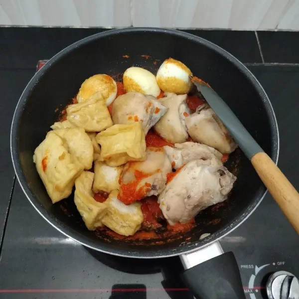 Masukkan ayam, telur, dan tahu. Aduk rata.