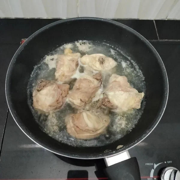 Potong-potong ayam, lalu rebus dengan air dan sedikit garam hingga mendidih. Tiriskan ayam dan buang air rebusannya. Kemudian, sisihkan.