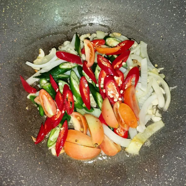 Masukkan cabai dan tomat, lalu tumis sampai sedikit layu.