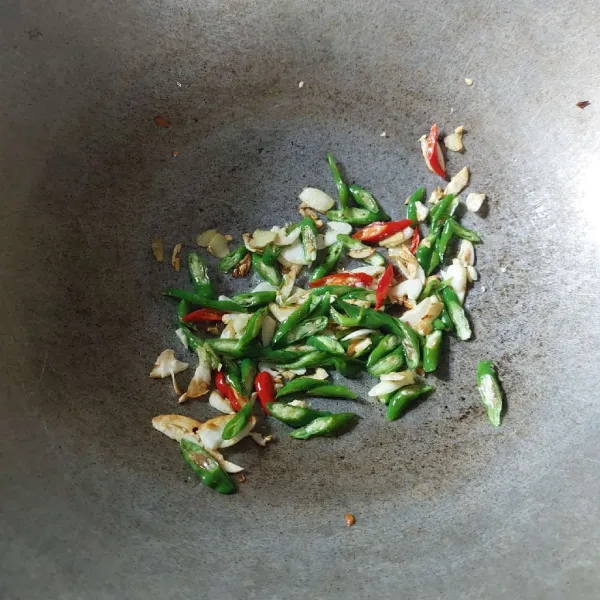 Tumis satu per satu bawang putih, jahe, cabe merah, dan cabe hijau.