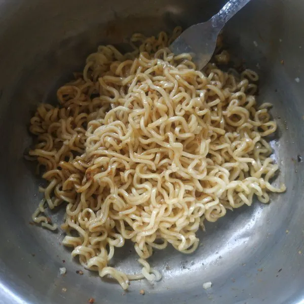 Tiriskan mie kemudian tambahkan bumbunya aduk rata.