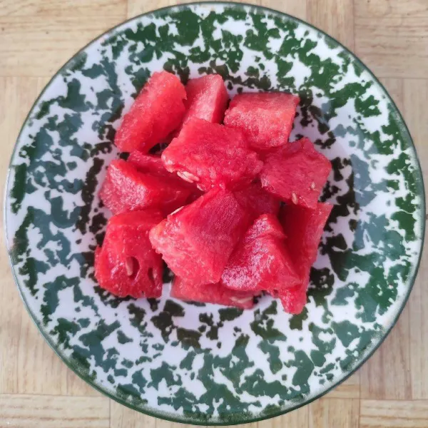 Potong dadu buah semangka, kemudian masukkan dalam gelas.