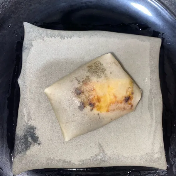 Lapis kedua kulit lumpia kita letakkan diatasnya kulit lumpia yang sudah di lipat sebelumnya dan beri olesan air di tiap sisi untuk merekatkan kulit lumpia yang mau dilipat