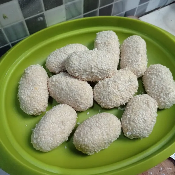 Celupkan onde ke air lalu gulingkan ke wijen, lakukan sampai selesai