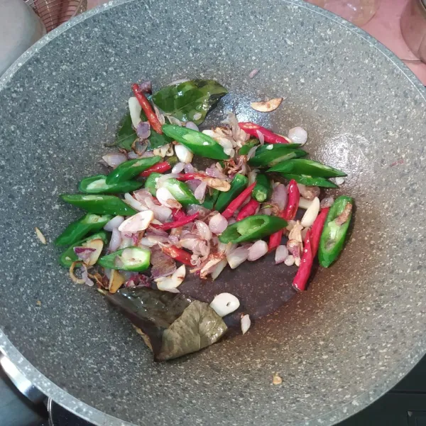 Tumis bawang merah dan bawang putih sampai wangi. Setelah itu, masukkan irisan cabe.