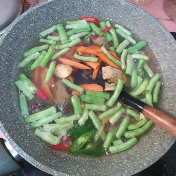Tuang air rebusan daging, masukkan wortel dan buncis.