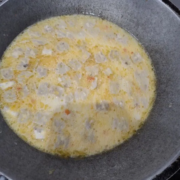 Masukkan tempe, kunyit bubuk, ketumbar bubuk, lada bubuk, garam, dan penyedap rasa.