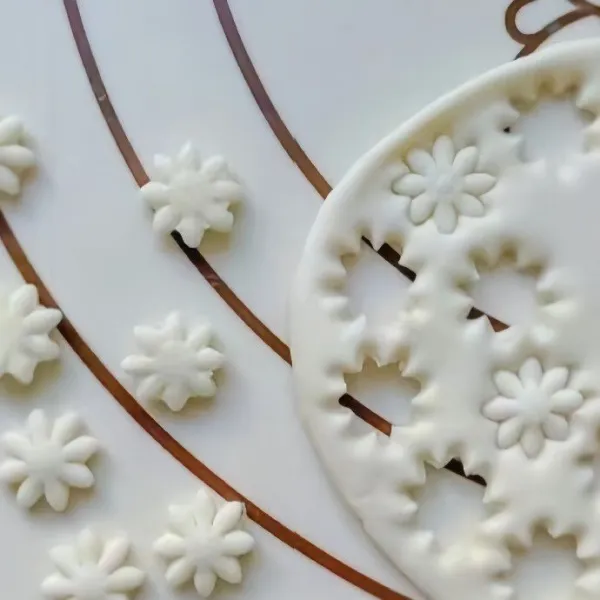 Gunakan alat pemotong berbentuk bunga untuk menghias bagian tengah donat. Gunakan cetakan untuk membuat bentuk daun untuk hiasan