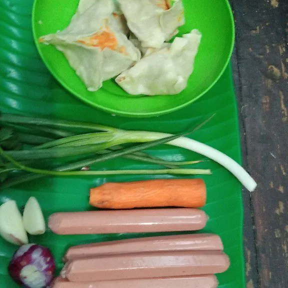 Potong wortel berbentuk dadu. Iris sosis sepanjang ±2 cm, lalu belah menjadi 4 bagian tanpa terputus. Rajang kasar daun prei, kemudian geprek bawang putih dan jahe.