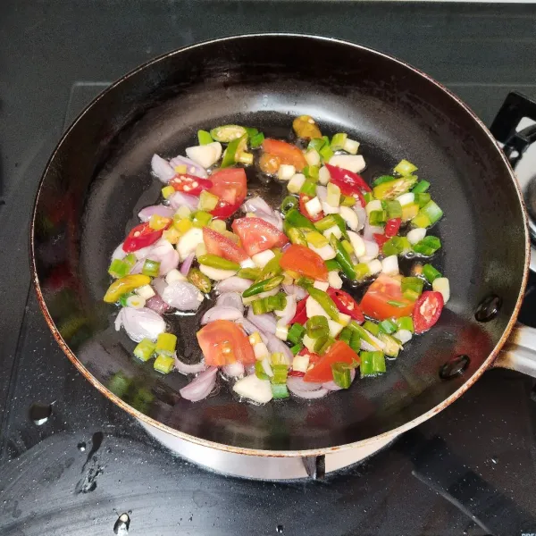 Tumis bawang merah, bawang putih, cabe merah, cabe rawit, tomat dan daun bawang hingga layu