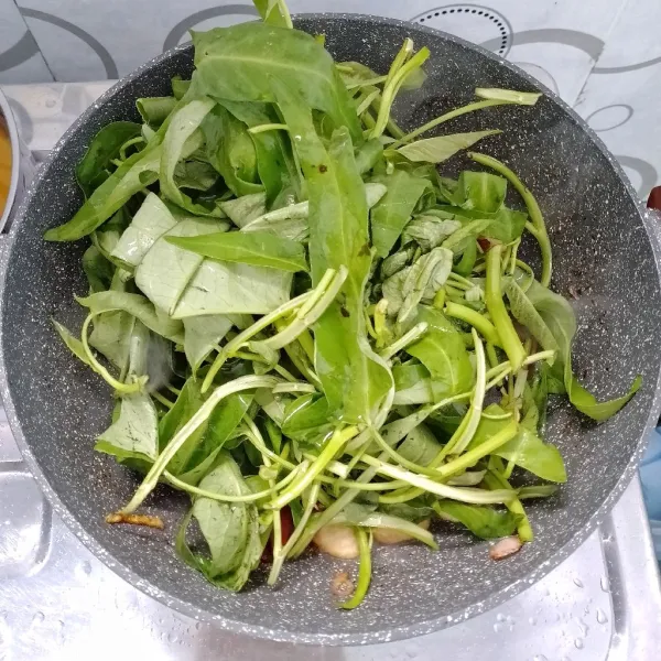 Masukkan kangkung dan sedikit air. Aduk rata. Masak sampai layu. Icip rasa. Sajikan.