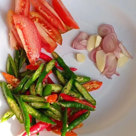 Iris semua bumbu seperti bawang merah, bawang putih, tomat, dan cabe