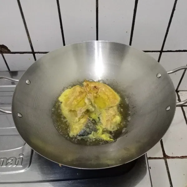 Panaskan minyak, goreng ikan di api sedang hingga matang.