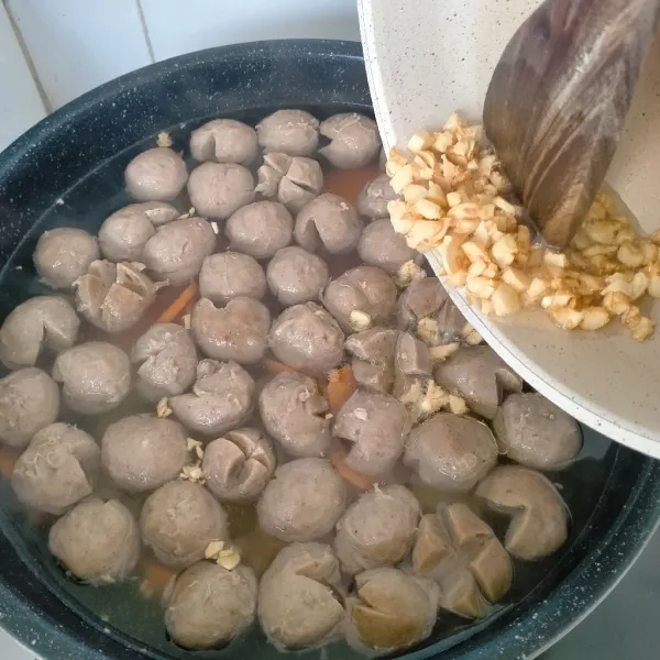 Masukan tumisan bawang putih ke dalam kuah bakso