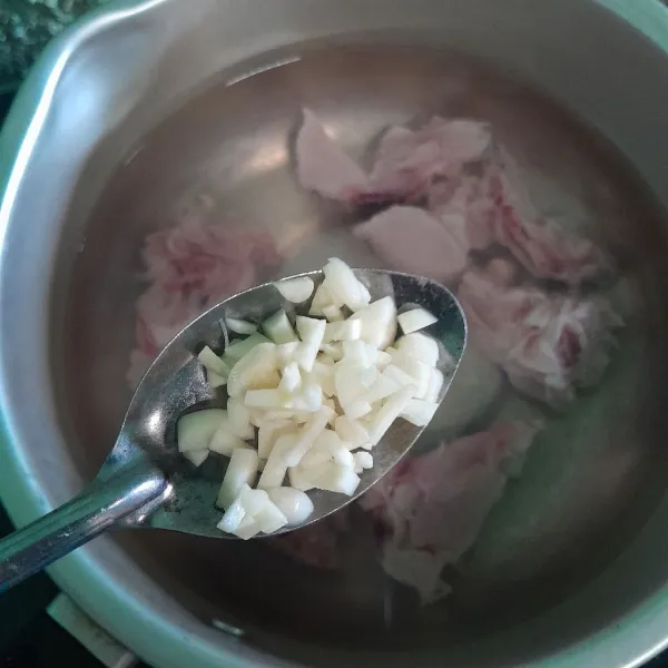 Masukkan ke dalam panci air, tulangan ayam lalu beri  bawang putih cincang