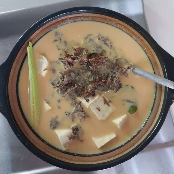 Tambahkan tahu dan jamur grigit, masak hingga keluar minyak.