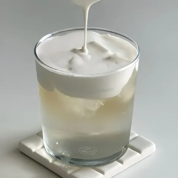 Tambahkan 30 gr krim susu yang telah dikocok ke atas minuman dalam gelas