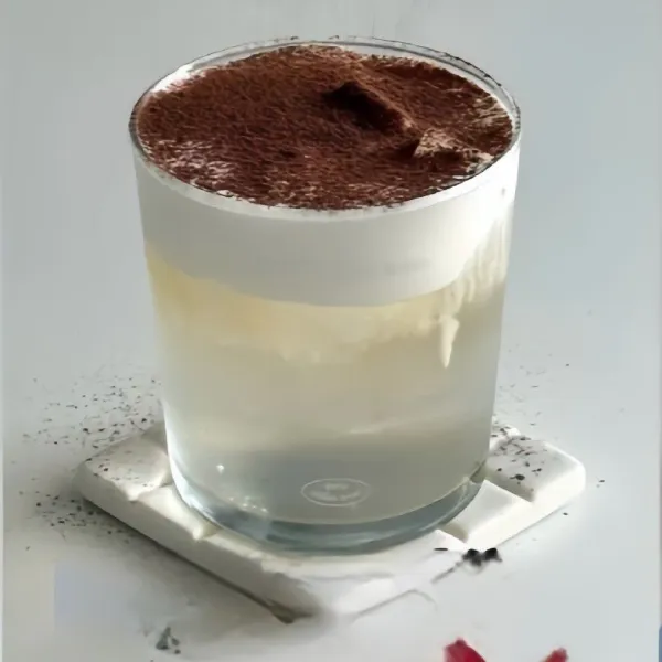 Taburkan bubuk cokelat atau bubuk kayu manis di atas krim susu sebagai hiasan