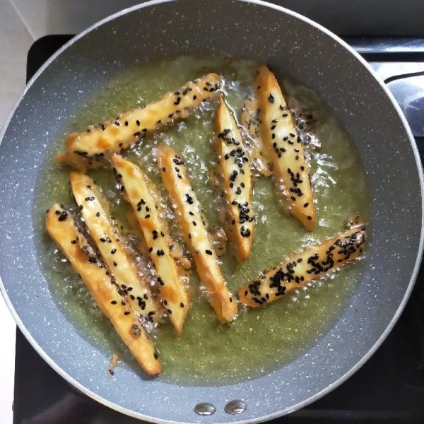 Panaskan minyak, kemudian goreng stik ubi hingga matang dan kuning kecoklatan, lalu angkat dan tiriskan