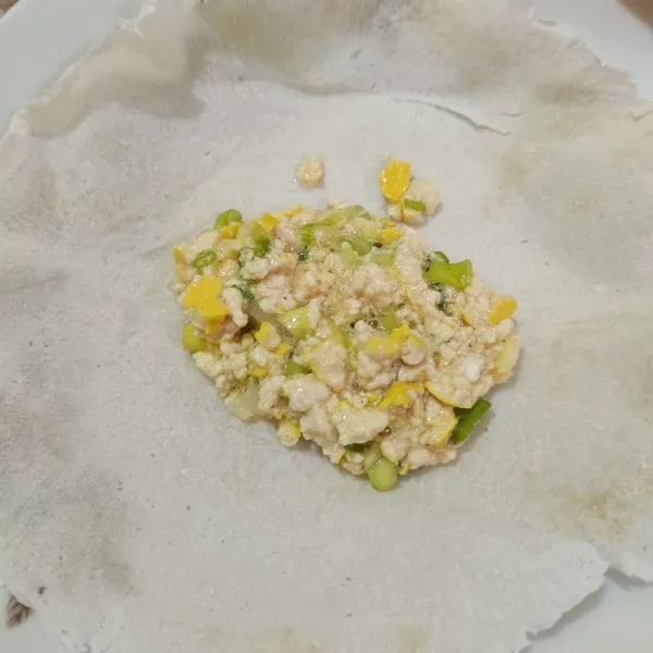 Ambil selembar kulit lumpia, lalu tambahkan adonan tahu secukupnya.