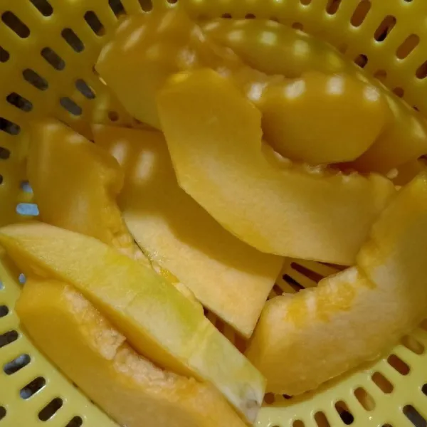 Kupas labu kuning buang biji nya lalu iris tipis cuci sampai bersih
