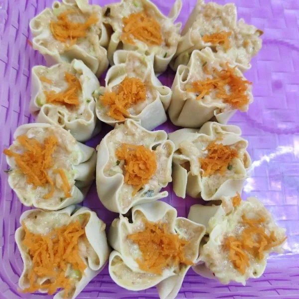 Lalu cetak adonan dimsum dengan kulit dimsum seperti ini, lalu beri toping sedikit parutan wortel