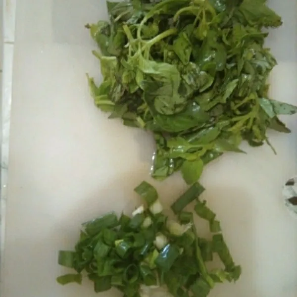 Iris semua daun kemangi dan bawang daun.