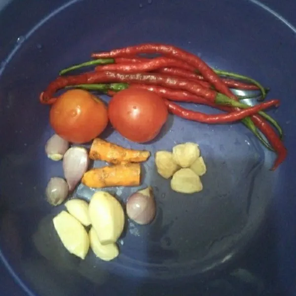 Siapkan bawang merah, bawang putih, cabai keriting, tomat, kemiri dan kunyit lalu ulek/blender sampai halus.