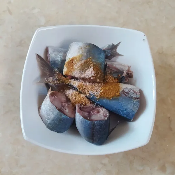 Campur ikan, garam dan kunyit bubuk, aduk rata.
