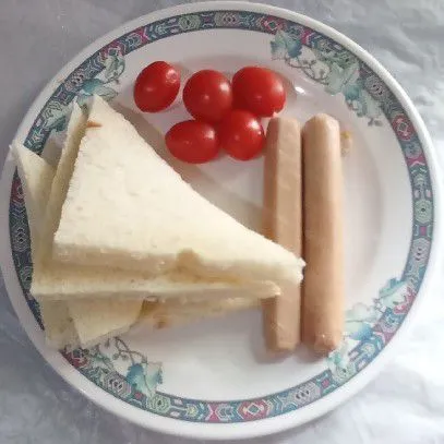 Karena saya memakai roti berkulit, maka kulitnya saya potong. Kerat-kerat kedua sisi sosis. Cuci bersih tomat ceri.