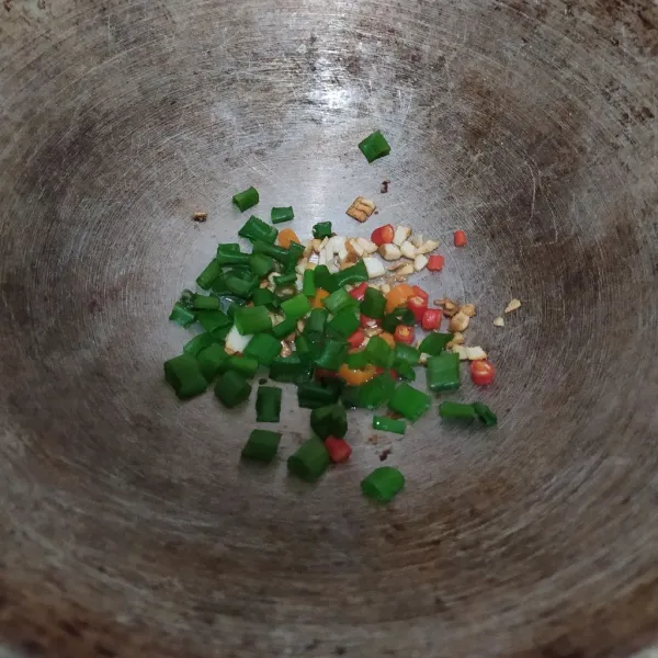 Masukkan daun bawang dan cabai, aduk rata. Tumis sebentar.