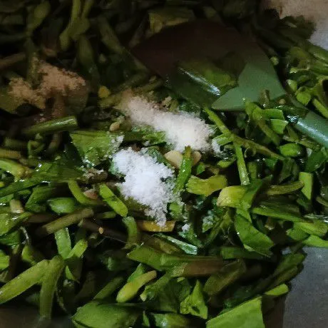 Masukkan daun genjer, garam, gula pasir, dan kaldu penyedap, aduk-aduk lalu tes rasa.