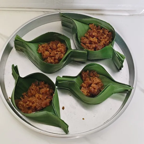 Kemudian untuk isian nya, masukan irisan gula merah banyaknya sesuai selera ke dalam cetakan daun yg terbuat dari daun pisang.