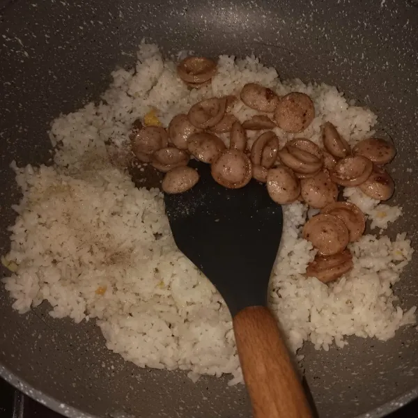 Masukkan sosis. Kemudian bumbui dengan sedikit garam, merica, dan kaldu bubuk. Lalu, aduk sampai tercampur rata.