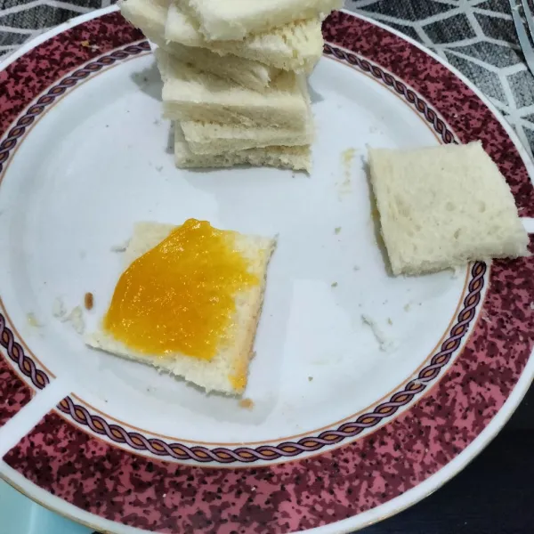 Langkah yang pertama potong roti tawar sesuai selera lalu olesi dengan selai srikaya