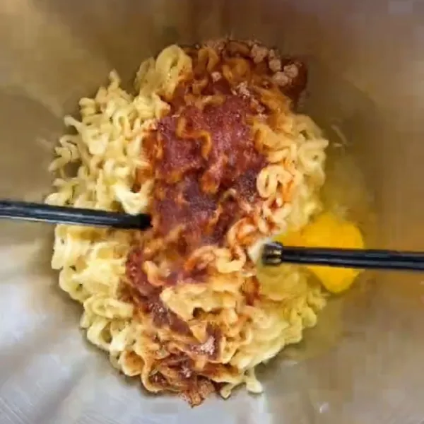 Masukkan bumbu bumbu mie lalu tambahkan 1 butir telur.
