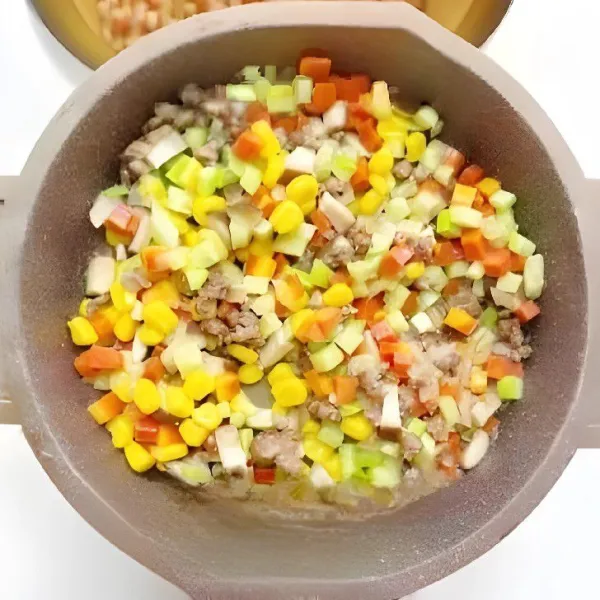 Tambahkan 30 gr wortel dan 30 gr labu kuning, tumis hingga sayuran sedikit lunak.  Masukkan 30 gr jagung manis pipil, tambahkan 2 gr garam dan 5 ml kecap asin, aduk rata. Angkat dan sisihkan.