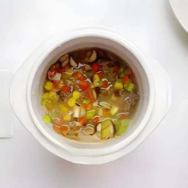 Tambahkan bahan yang sudah ditumis ke dalam panci, aduk rata. Masak dengan api kecil selama 1,5 jam hingga semua bahan matang sempurna dan teksturnya menyerupai bubur kental.