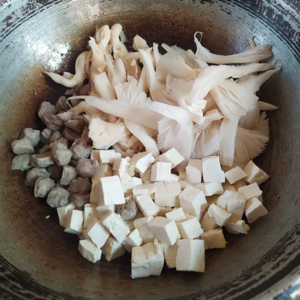 Masukkan jamur tiram, tahu dan bakso, aduk rata.  Tumis sebentar hingga jamur layu.