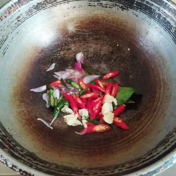 Panaskan minyak, tumis bawang merah, bawang putih, cabai, daun salam hingga harum dan matang. Gunakan api sedang.