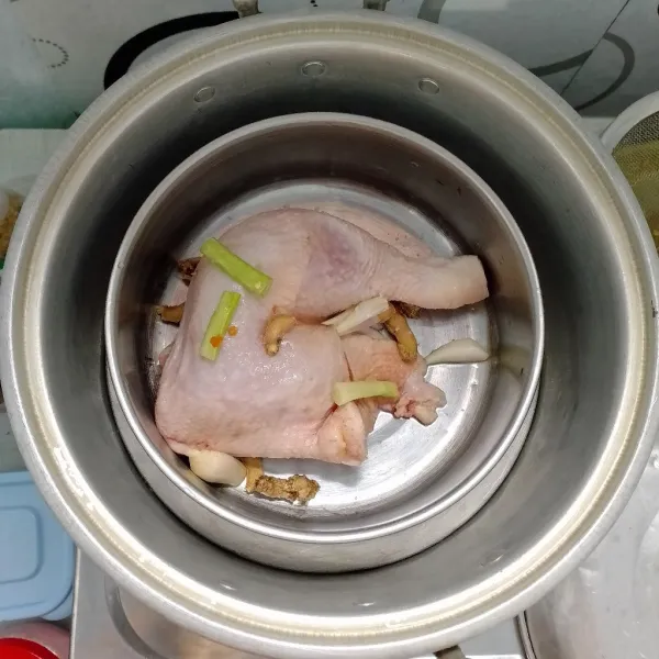 Kukus ayam bersama jahe, daun bawang dan garam sampai matang.