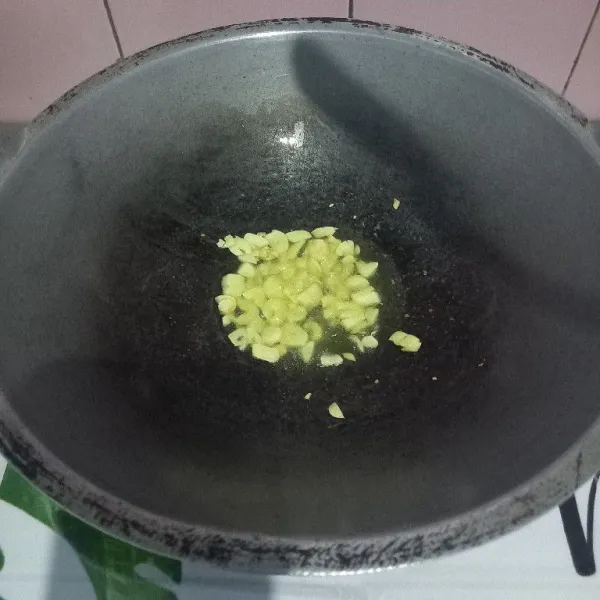 Tumis bawang putih hingga harum.