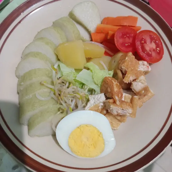 Tata lontong, sayuran, telur, tomat lalu siram bumbu kacang. Beri kerupuk, sambal dan bawang goreng.