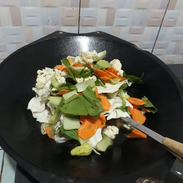 Masukkan sayuran dan sisa bahan lainnya, kecuali larutan maizena. Masak sebentar saja asal mendidih dan sayuran layu.