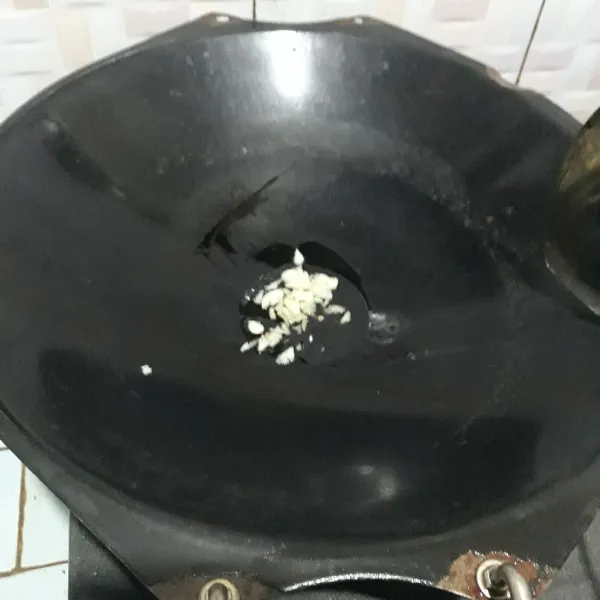 Tumis bawang putih hingga harum.